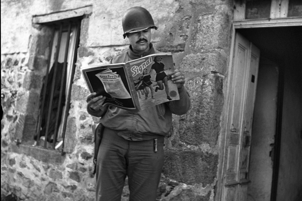 Soldado estadounidense leyendo la revista alemana Signal en Francia